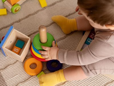 high-angle-kid-playing-with-colorful-toys