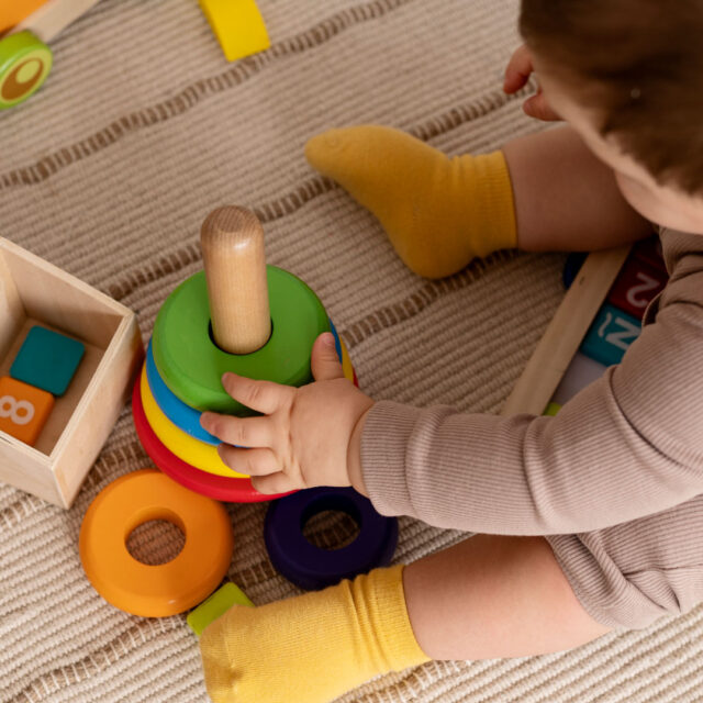 high-angle-kid-playing-with-colorful-toys